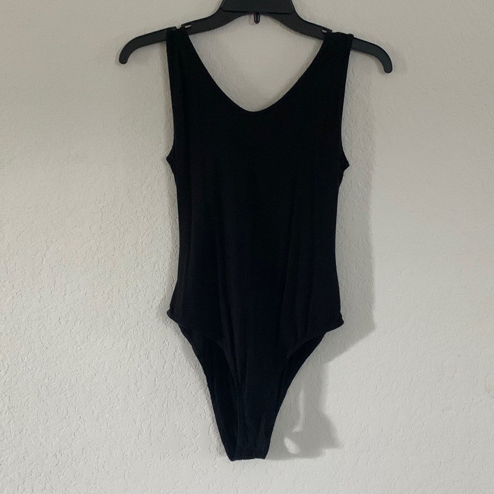Backless, black body suit